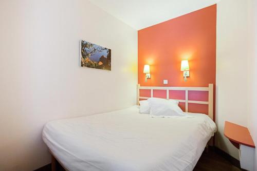 1 dormitorio con cama blanca y pared de color naranja en Résidence le Village de Cap Esterel - maeva Home - Appartement 2 pièces 5 p 27, en Saint-Raphaël