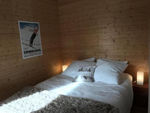 a bed in a room with a wooden wall at Résidence Les Arolles - 2 Pièces pour 6 Personnes 24 in Valloire