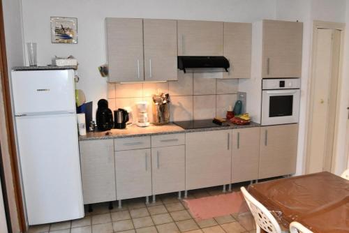 - une cuisine avec un réfrigérateur-congélateur blanc à côté d'une table dans l'établissement Résidence Hawai 1 - VILLA T2 CABINE MEZZANINE 6 couchages PORT LEUCATE MAE-4914, à Port-Leucate