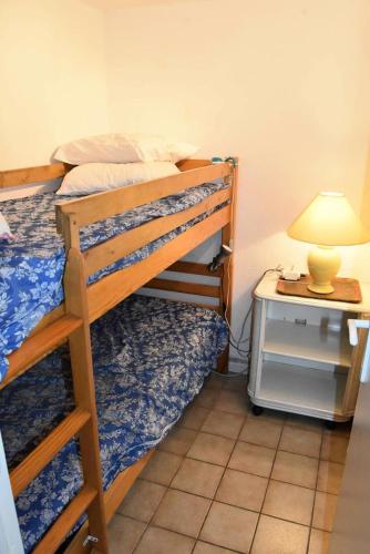 - une chambre avec 2 lits superposés et une table avec une lampe dans l'établissement Résidence Hawai 1 - VILLA T2 CABINE MEZZANINE 6 couchages PORT LEUCATE MAE-4914, à Port-Leucate