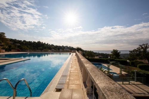 Cette chambre offre une vue sur la piscine et le soleil du ciel. dans l'établissement Les Issambres Corniche - maeva Home - Appartement 2 pièces 5 personnes Sélection MAE-1819, aux Issambres