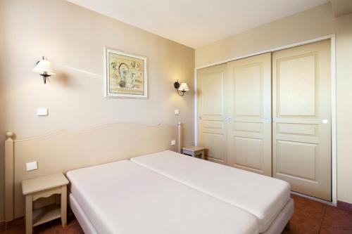 une chambre avec un lit blanc et un placard dans l'établissement Les Issambres Corniche - maeva Home - Appartement 2 pièces 5 personnes Sélection MAE-1819, aux Issambres