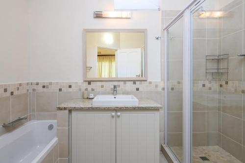 a white bathroom with a sink and a shower at San Lameer Villa 2608 - 4 Bedroom Classic - 8 pax - San Lameer Rental Agency in Southbroom