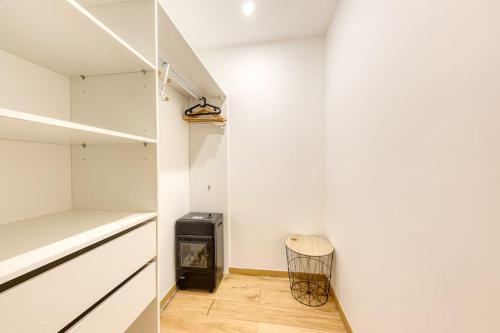 - un dressing avec un mur blanc et un tabouret dans l'établissement Loft Haut standing 101 m2 - Proche Paris tour eiffel - 3 min metro, à Paris