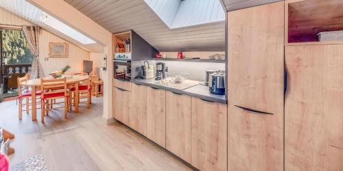 a kitchen with wooden cabinets and a dining room at Résidence Le Centre - 3 Pièces pour 6 Personnes MAE-0544 in Champagny-en-Vanoise