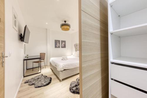 une petite chambre avec un lit et un bureau dans l'établissement Loft Haut standing 101 m2 - Proche Paris tour eiffel - 3 min metro, à Paris