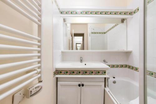 une salle de bain blanche avec un lavabo et un miroir dans l'établissement Village Pont Royal en Provence - maeva Home - Appartement 2 pièces 7 personnes Sélection MAE-2092, à Mallemort