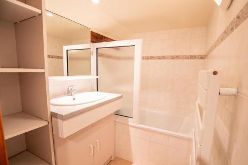 La salle de bains est pourvue d'un lavabo, d'un miroir et d'une baignoire. dans l'établissement Résidence Les Epervieres - 2 Pièces pour 6 Personnes 84, à Villarodin-Bourget