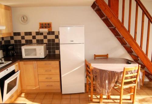 une cuisine avec un réfrigérateur blanc et une table dans l'établissement Résidence Grande Bleue - VILLA 3 PIECES 6 couchages PORT LEUCATE MAE-5194, à Port-Leucate