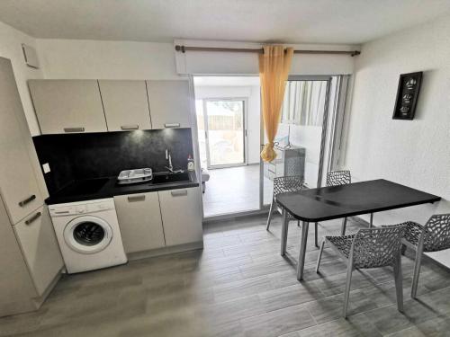 une cuisine et une salle à manger avec une table et une table ainsi qu'une salle à manger dans l'établissement Résidence Les Nefs Des Sables - STUDIO 4 PERSONNES 5 couchages PORT LEUCATE. Réf: 2NEF_7K4 MAE-5224, à Port-Leucate
