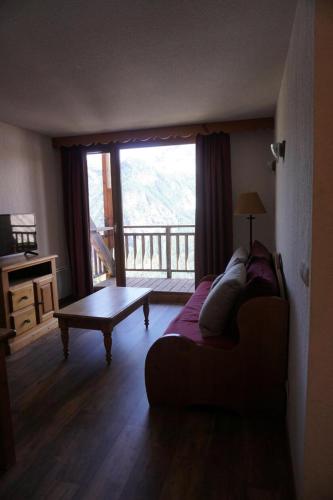 un salon avec un canapé, une table et une fenêtre dans l'établissement Résidence Cristallines - 2 Pièces cabine 6 personnes MAE-2434, à Orcières