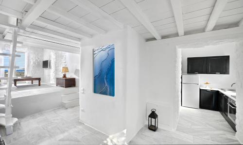 a white room with a bathroom with a tv on the wall at Mykonos Dream Villas in Elia