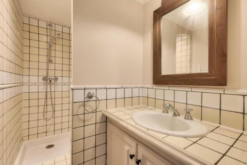 une salle de bain avec un lavabo et une douche avec un miroir dans l'établissement Les Bastides aux Restanques du Golfe de St Tropez - maeva Home - Bastide vue mer pour 6 personnes - Prestige MAE-2259, à Grimaud