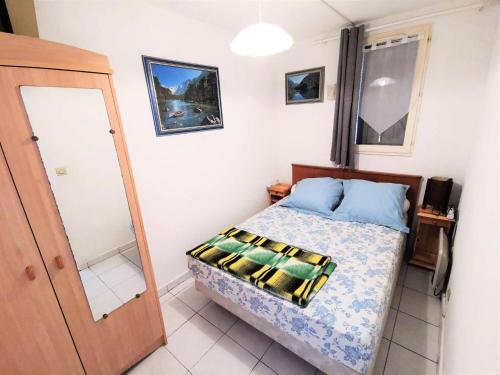 une petite chambre avec un lit et un miroir dans l'établissement Résidence LE CARLTON - 2 Pièces pour 4 Personnes 04, à Port-Leucate