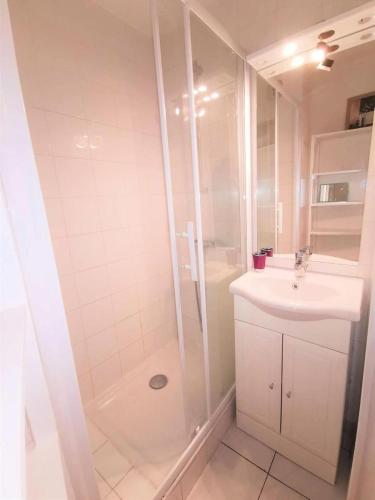 une salle de bain blanche avec une douche et un lavabo dans l'établissement Résidence LE CARLTON - 2 Pièces pour 4 Personnes 04, à Port-Leucate