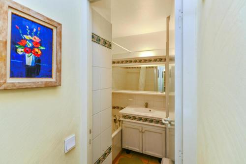 La salle de bains est pourvue d'un lavabo et d'une peinture murale. dans l'établissement Village Pont Royal en Provence - maeva Home - Appartement 2 pièces 5 personnes Confort MAE-2264, à Mallemort
