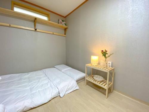 a bedroom with a bed and a table with a lamp at Hanok guesthouse Ann 