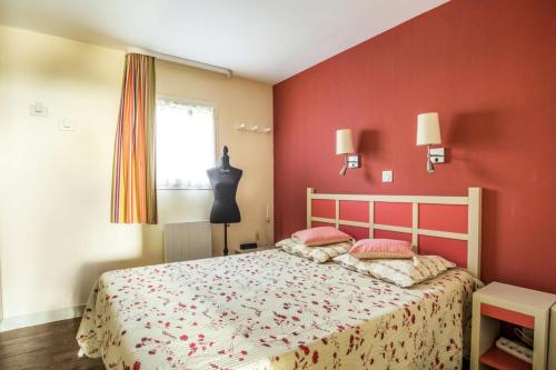sypialnia z łóżkiem i czerwoną ścianą w obiekcie Résidence Les Parcs de Grimaud - maeva Home - Appartement 2 pièces 4 personnes Prestige MAE-2246 w mieście Grimaud