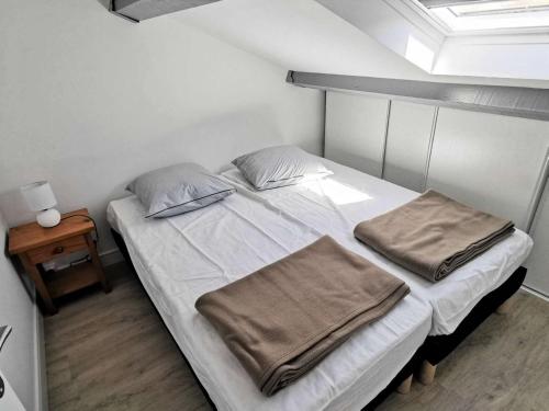 une chambre avec un lit avec des draps blancs et des oreillers dans l'établissement Résidence Grande Bleue - Villa trois pièces 6 couchages PORT LEUCATE. Réf: 3GB_152 MAE-5234, à Port-Leucate