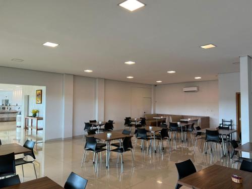 a restaurant with tables and chairs in a room at Hotel PetroShop in Palmas