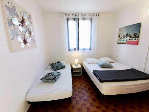 deux lits jumeaux dans une chambre avec fenêtre dans l'établissement Résidence Marysable - Appartement trois pièces avec terrasse pour 7 personnes à Port Leucate. Réf: 1MAR_106 MAE-5254, à Port-Leucate