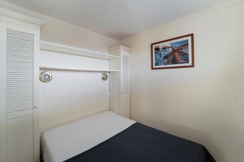 a small bedroom with a bed and a picture on the wall at Résidence Bleu Marine - maeva Home - Appartement 2 pièces 4 personnes Confort MAE-2510 in Lacanau