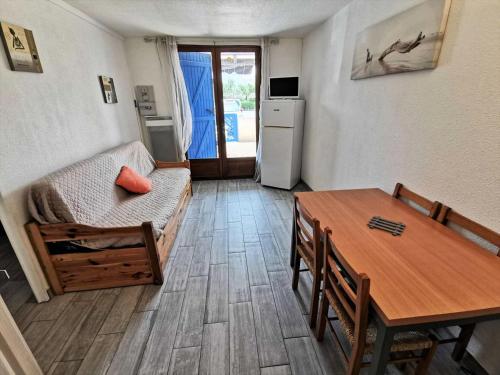 un salon avec une table et un canapé et une cuisine dans l'établissement Résidence Grande Bleue - 2 Pièces 4 couchages PORT LEUCATE MAE-5264, à Port-Leucate