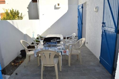 une table et des chaises assises sur une terrasse dans l'établissement Résidence Le Cap De Front - VILLA 3 PIECES 6 couchages PORT LEUCATE MAE-5314, à Port-Leucate