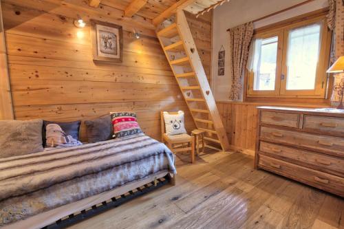 a log cabin bedroom with a bed and a ladder at Résidence La Beguette - 2 Pièces pour 6 Personnes 54 in Notre-Dame-de-Bellecombe
