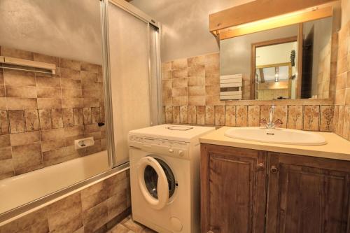 ein Badezimmer mit einer Waschmaschine und einem Waschbecken in der Unterkunft Résidence La Beguette - 2 Pièces pour 6 Personnes 54 in Notre-Dame-de-Bellecombe
