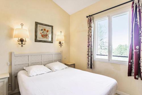 ein Schlafzimmer mit einem weißen Bett und einem Fenster in der Unterkunft Les maisons Le Rouret - maeva Home - Maison 3 pièces 6 personnes Sélection MAE-3026 in Grospierres