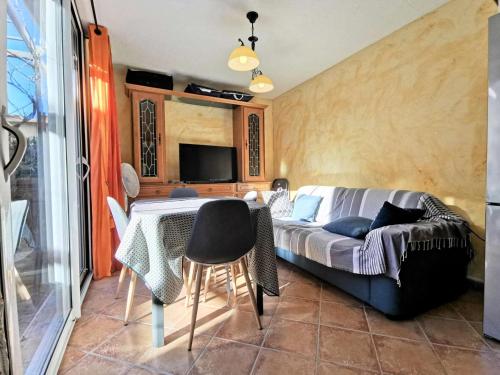 Cette chambre comprend un lit, une table et un canapé. dans l'établissement Résidence Le Cres De La Ginestelle - Villa 3 pièces - 6 personnes - PORT LEUCATE MAE-5384, à Port-Leucate