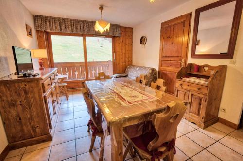 une salle à manger avec une table et une cuisine dans l'établissement Résidence Le Schuss 1 - Appartement sur le front de neige des Evettes MAE-2734, à Notre-Dame-de-Bellecombe
