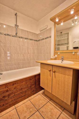 une salle de bain avec une baignoire et un lavabo et une baignoire dans l'établissement Résidence Le Schuss 1 - Appartement sur le front de neige des Evettes MAE-2734, à Notre-Dame-de-Bellecombe