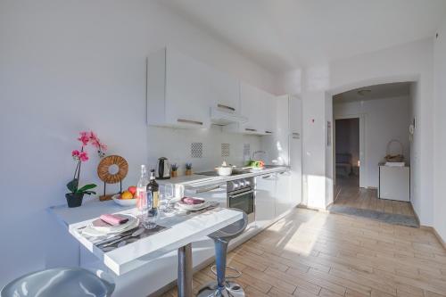 a kitchen with white cabinets and a table with dishes at La Finestra di Laura - Happy Rentals in Laveno-Mombello