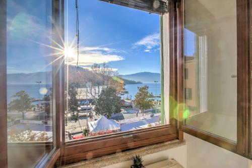 a window with a view of a city at La Finestra di Laura - Happy Rentals in Laveno-Mombello