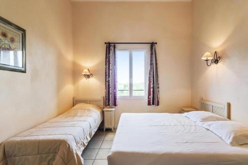 deux lits dans une chambre avec une fenêtre dans l'établissement Les maisons Le Rouret - maeva Home - Maison 2 pièces 5 personnes Sélection MAE-3554, à Grospierres