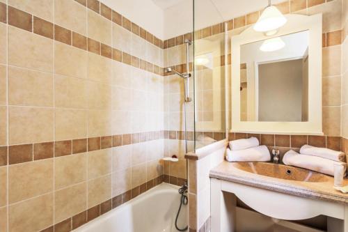 une salle de bain avec un lavabo, une baignoire et un miroir dans l'établissement Les maisons Le Rouret - maeva Home - Maison 2 pièces 5 personnes Sélection MAE-3554, à Grospierres