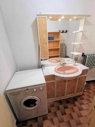 une salle de bain avec un lavabo et une machine à laver dans l'établissement Résidence Maryland 1 Et 2 - Appartement deux pièces coin nuit 6 couchages PORT LEUCATE. Réf: 1MRL_3D MAE-5424, à Port-Leucate