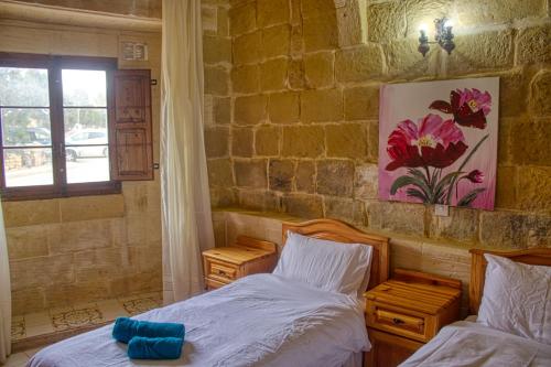 a bedroom with two beds and a window at Gabriel B&B in San Lawrenz