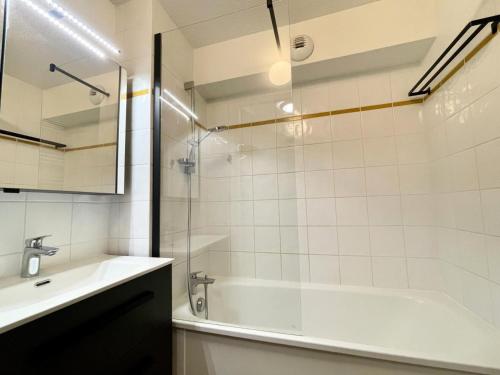 a bathroom with a bath tub and a sink at Les Chalets Des Evettes - 3 Pièces pour 6 Personnes 44 in Notre-Dame-de-Bellecombe
