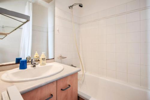 une salle de bain avec un lavabo et une baignoire dans l'établissement Résidence Les Océanes - maeva Home - Studio 5 personnes Confort - vue mer MAE-3803, à Pornichet