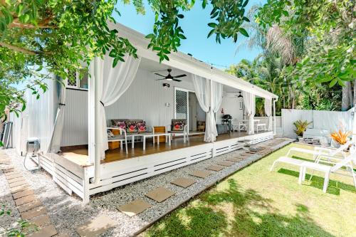 an outdoor living room with a white pavilion at Private Outdoor Spa, Fire Pit, Cinema Room - THE COTTAGE COOLUM BEACH in Coolum Beach