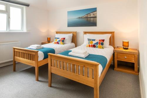two twin beds in a room with two night stands at Brighton & Hove Beach - group or family fun in Brighton & Hove