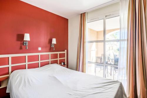 une chambre avec un lit et une grande fenêtre dans l'établissement Résidence le Village de Cap Esterel - maeva Home - Appartement 2 pièces 5 personnes Sélection MAE-4514, à Saint-Raphaël