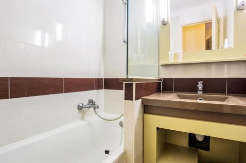 une salle de bain avec un lavabo et une baignoire dans l'établissement Résidence le Village de Cap Esterel - maeva Home - Appartement 2 pièces 5 personnes Sélection MAE-4514, à Saint-Raphaël