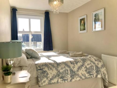 a bedroom with a bed and a lamp and a window at Charming Coastal Getaway - Pembroke in Pembrokeshire