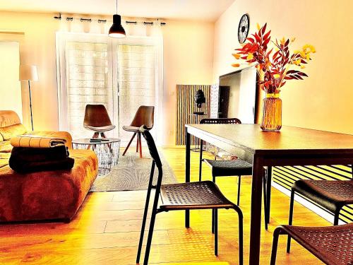 sala de estar con sofá, mesa y sillas en Better Living - Villa - Exklusiv Studio 76qm, en Montabaur