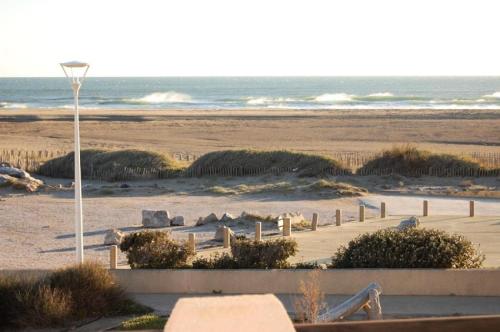 une vue d'une plage avec un lampadaire et l'océan dans l'établissement Résidence Grande Bleue - APPT T2 CAB OU MEZZ 6 couchages PORT LEUCATE MAE-5594, à Port-Leucate