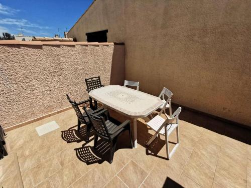a table and chairs on a rooftop patio at Résidence LES LEUCATINES 1 - Maisons & Villas pour 6 Personnes 24 in Port Leucate